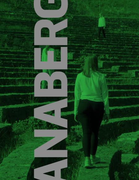 baner informacyjny zawierający napis "anaberg", zielone zdjęcie w tle przedstawia grupę kobiet stojących na widowni amfiteatru