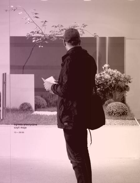 mężczyzna ogląda wystawę w galerii Aneks, widok na wnętrze wypełnione instalacją roślinną