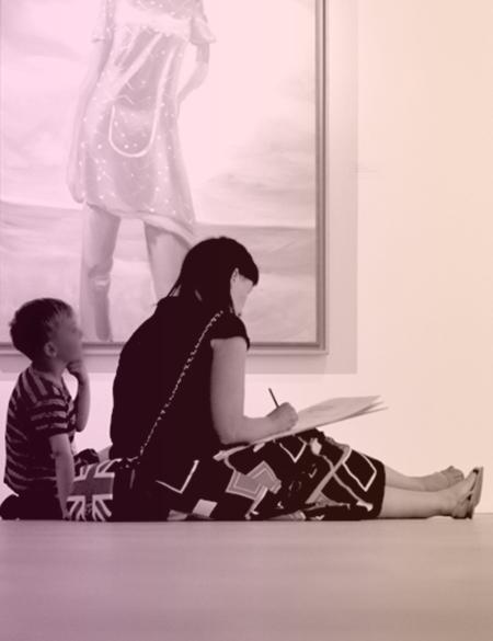 zdjęcie matki i dziecka siedzących na podłodze w galerii, patrzą na obraz