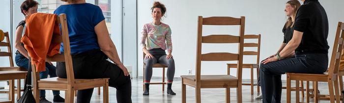 zdjęcie osób siedzących na krzesłach, w kręgu.