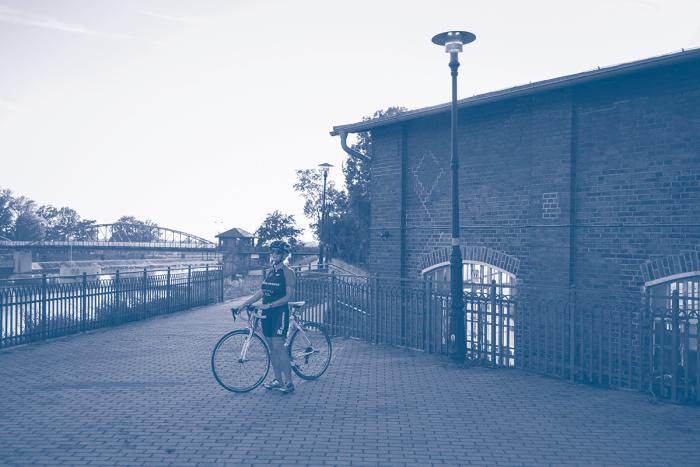 zdjęcie rowerzyski na tle odry i zabudować obok jazu w Opolu