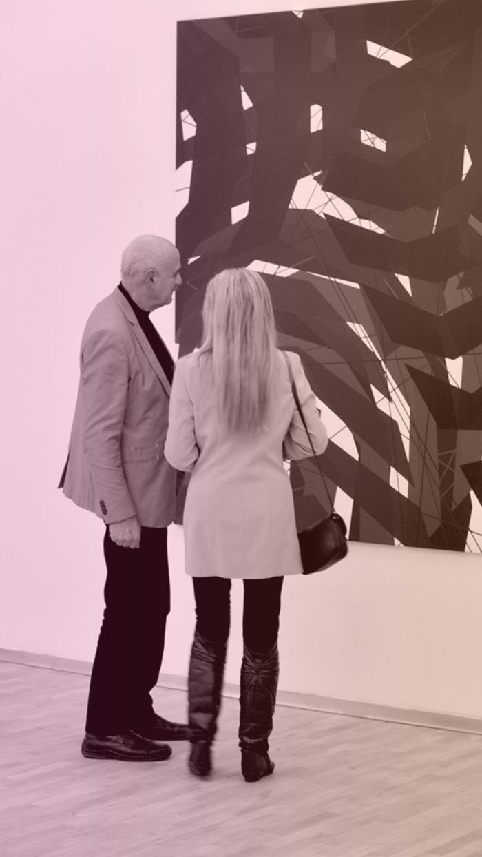 dwie osoby oglądają obraz w galerii