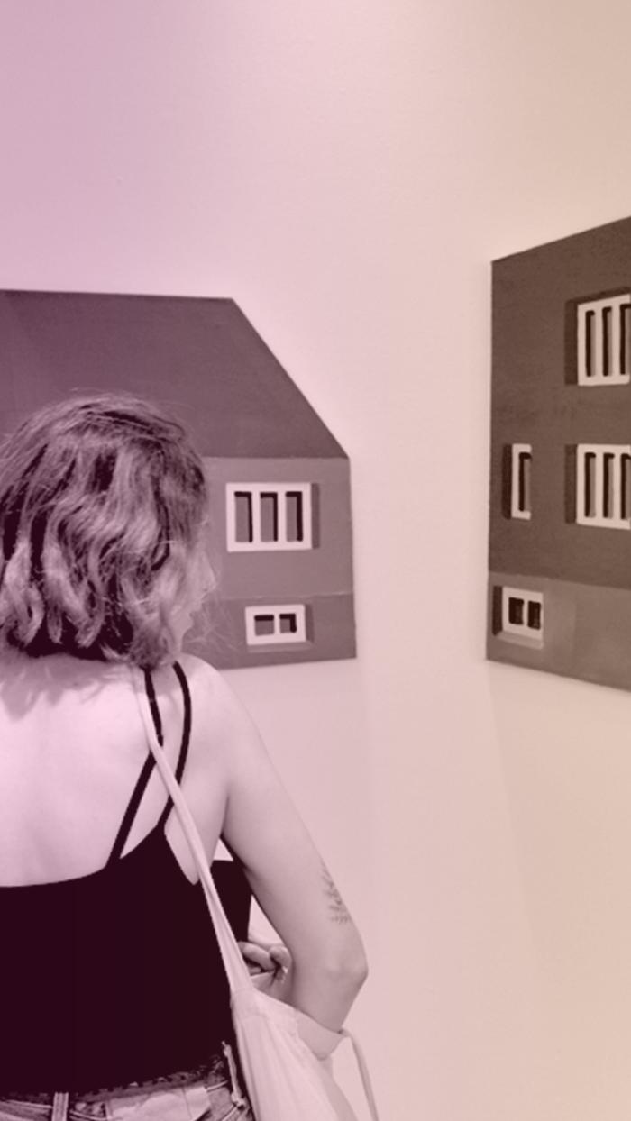 kobieta ogląda obrazy na ścianie