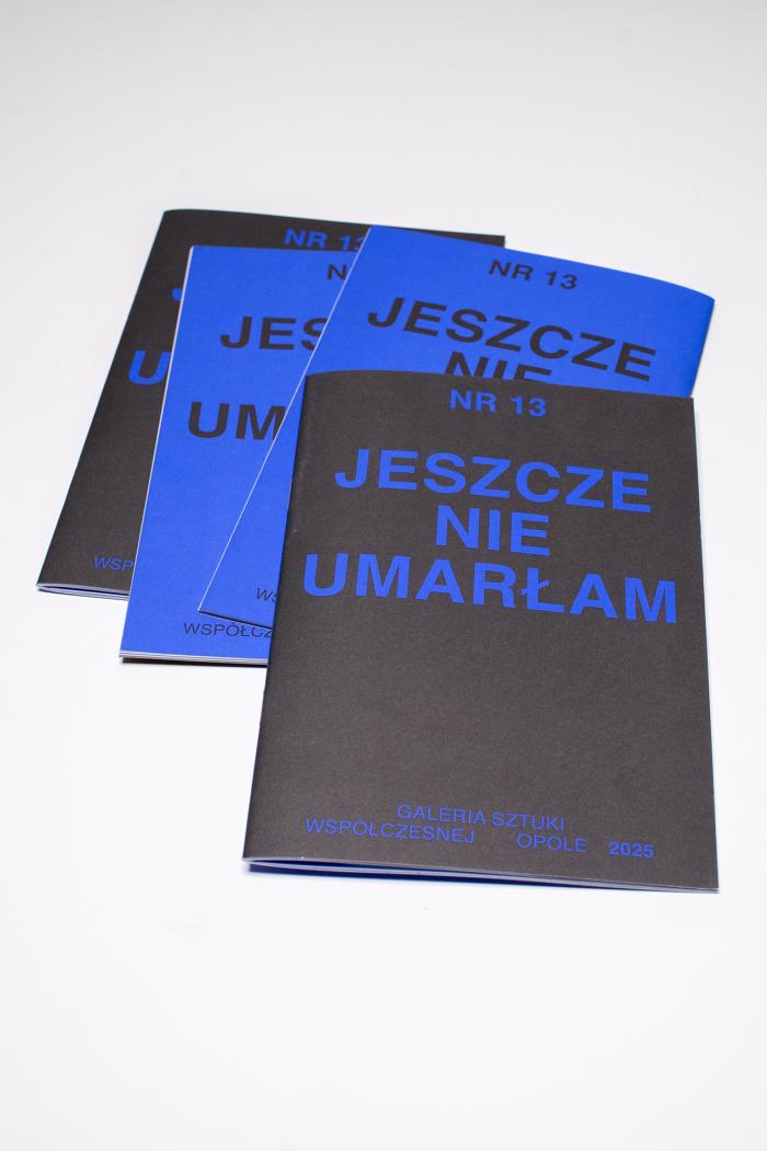 okładka gazetki z napisem: jeszcze nie umarłam, niebieskie lub czarne tło