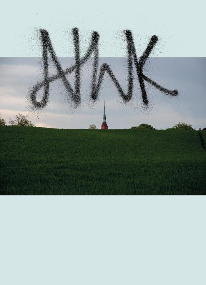 baner informacyjny, napis sprayem nwk, w tle miejscowość z koćiołem