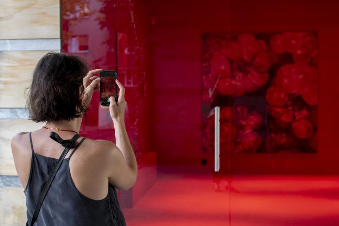 zdjęcie, widok na galerię aneks w Opolu, w tle czerwony obraz, na pierwszym planie oglądająca wystawę